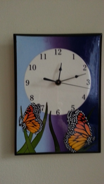 A clock with butterfly decoration